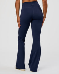 Woman wearing Fusion V-Contour High-Rise Flared Tall Legging Pockets - Future Navy | Model:Rosie | Size:S