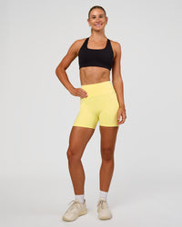 Woman wearing Fusion V-Contour Ultra High-Rise 4” Short Pockets - Yellow Fizz | Model:Emelia | Size:S