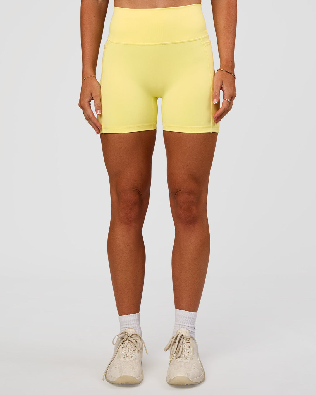 Woman wearing Fusion V-Contour Ultra High-Rise 4” Short Pockets - Yellow Fizz | Model:Emelia | Size:S