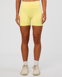 Woman wearing Fusion V-Contour Ultra High-Rise 4” Short Pockets - Yellow Fizz | Model:Emelia | Size:S