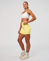 Woman wearing Fusion V-Contour Ultra High-Rise 6" Short Pockets - Yellow Fizz | Model:Emelia | Size:S