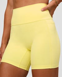 Woman wearing Fusion V-Contour Ultra High-Rise 6" Short Pockets - Yellow Fizz | Model:Emelia | Size:S