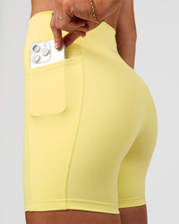 Woman wearing Fusion V-Contour Ultra High-Rise 6" Short Pockets - Yellow Fizz | Model:Emelia | Size:S