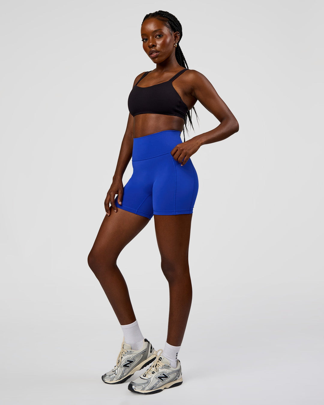 Woman wearing Fusion V-Contour Ultra High-Rise 4” Short Pockets - Electric Indigo | Model:Ellie | Size:S