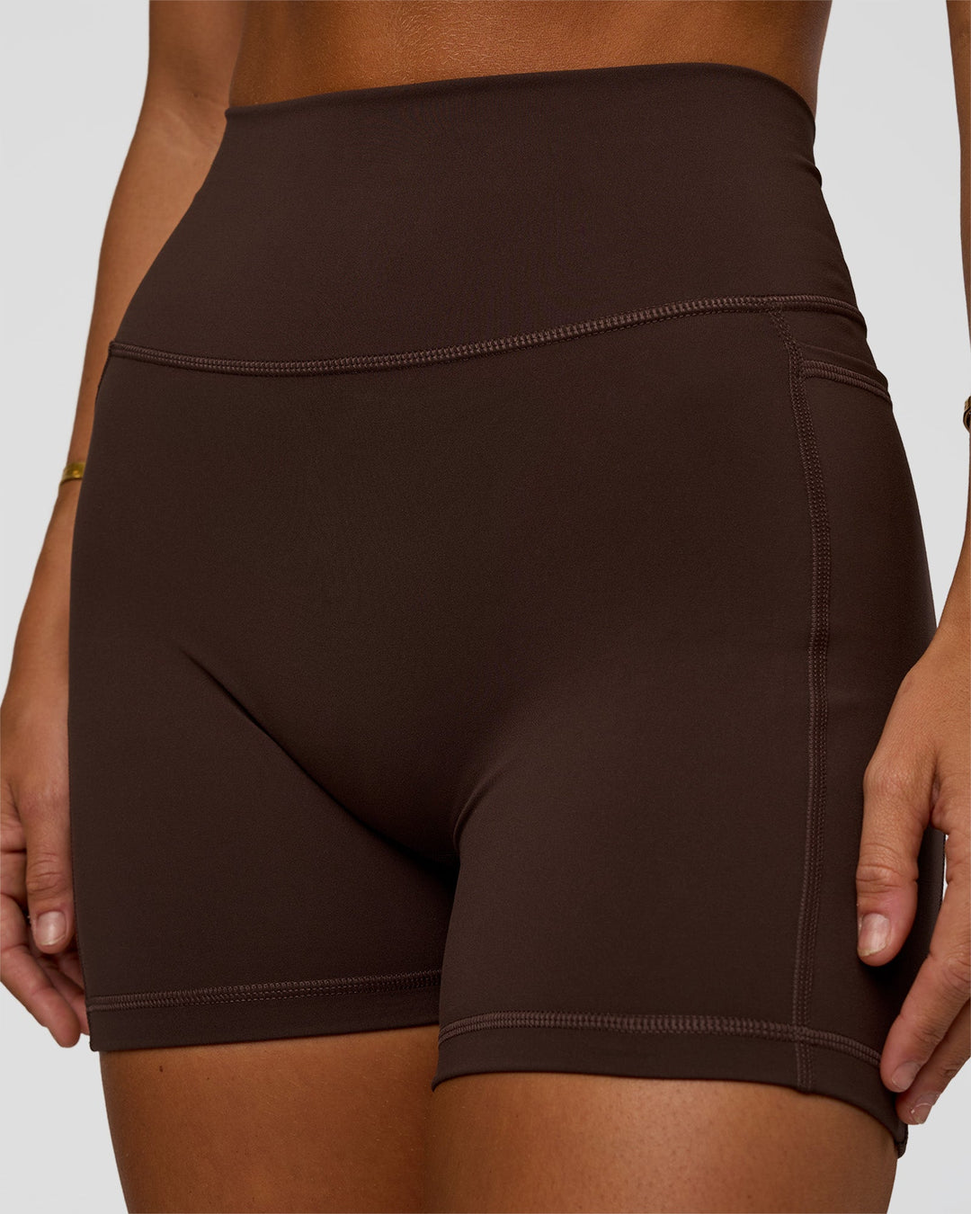 Woman wearing Fusion V-Contour Ultra High-Rise 4” Short Pockets - Hot Chocolate | Model:Amity | Size:S