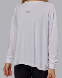 Woman wearing Go-To Long Sleeve FLXCotton Oversized Tee - White-Black | Model:Emilie | Size:S