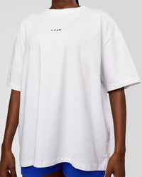 Woman wearing Go-To Run Club FLXCotton Oversized Tee - White-Electric Indigo | Model:Ellie | Size:S