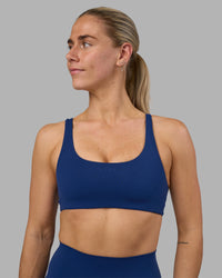 Woman wearing Impulse Reversible Sports Bra - Midnight Blue | Model:Hannah | Size:S