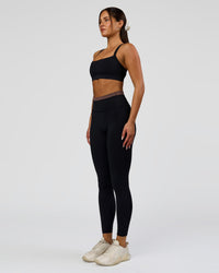 Woman wearing Liberate High-Rise Full Length Legging Pockets in Black-Cocoa Powder | Model:Bianca | Size:S