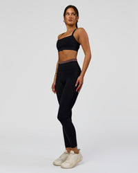 Woman wearing Liberate High-Rise Full Length Legging Pockets in Black-Cocoa Powder | Model:Bianca | Size:S