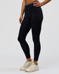 Woman wearing Liberate High-Rise Full Length Legging Pockets in Black-Cocoa Powder | Model:Bianca | Size:S