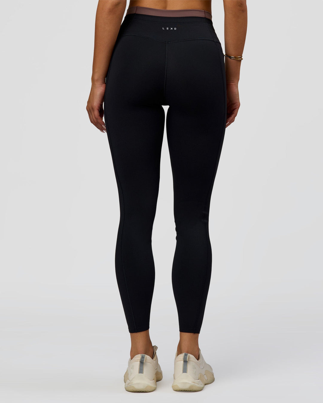 Woman wearing Liberate High-Rise Full Length Legging Pockets in Black-Cocoa Powder | Model:Bianca | Size:S