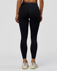Woman wearing Liberate High-Rise Full Length Legging Pockets in Black-Cocoa Powder | Model:Bianca | Size:S