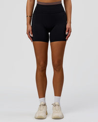 Woman wearing Liberate High-Rise 6" Short Pockets in Black-Cocoa Powder | Model:Bianca | Size:S