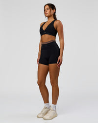Woman wearing Liberate High-Rise 4" Short Pockets in Black-Cocoa Powder | Model:Bianca | Size:S