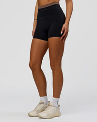 Woman wearing Liberate High-Rise 4" Short Pockets in Black-Cocoa Powder | Model:Bianca | Size:S