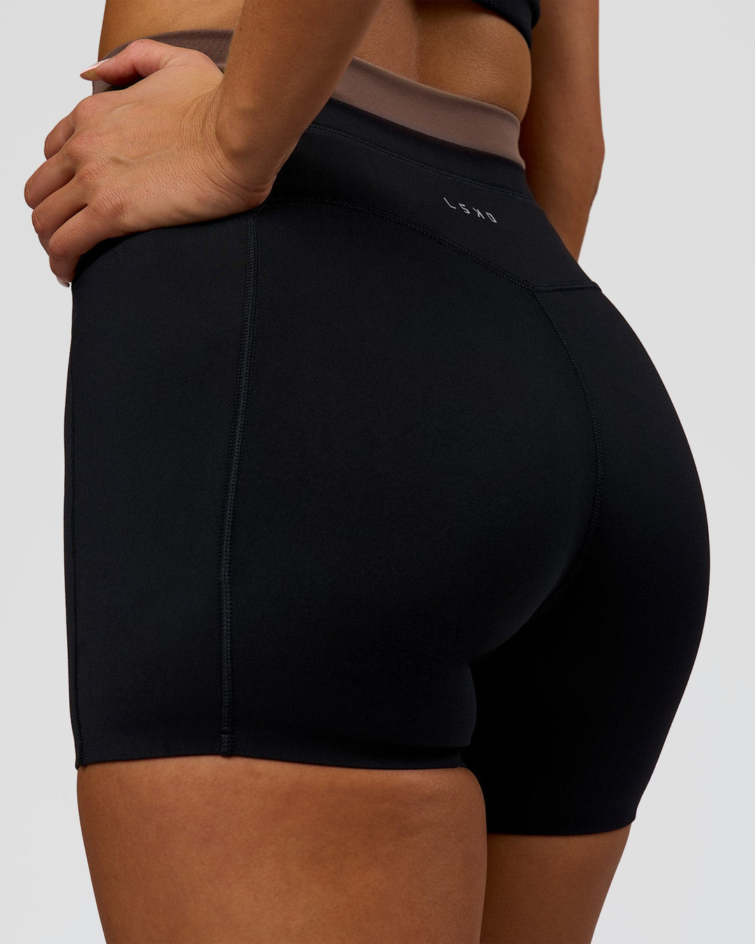 Woman wearing Liberate High-Rise 4" Short Pockets in Black-Cocoa Powder | Model:Bianca | Size:S