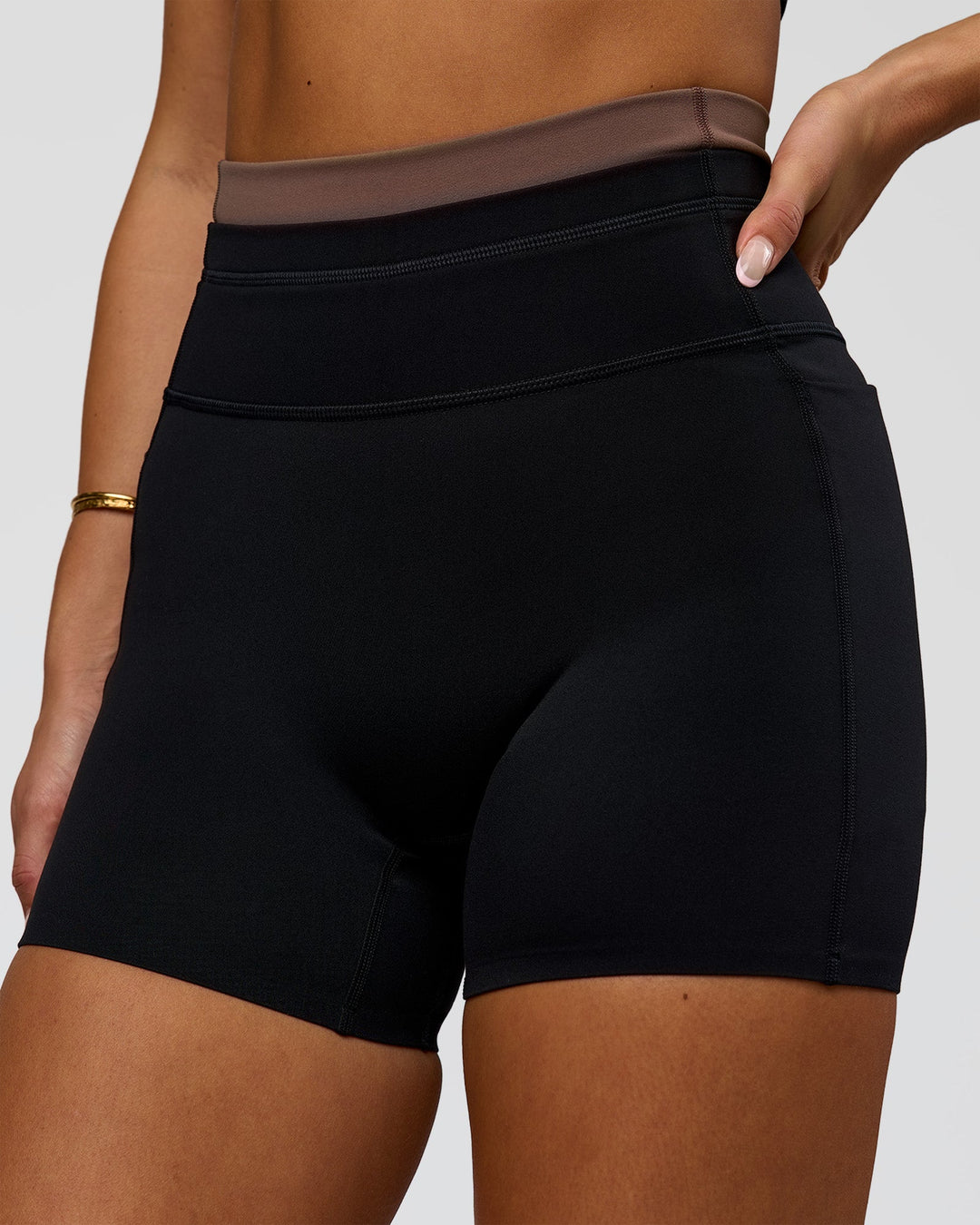 Woman wearing Liberate High-Rise 4" Short Pockets in Black-Cocoa Powder | Model:Bianca | Size:S