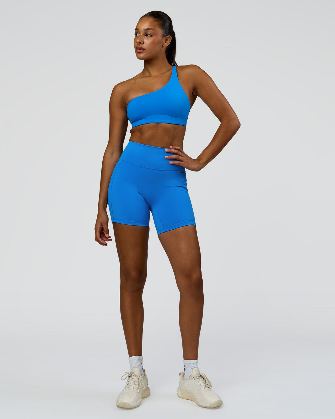 Woman wearing Muse Asymmetric Sports bra - Palace Blue | Model:Rosie | Size:S