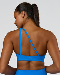 Woman wearing Muse Asymmetric Sports bra - Palace Blue | Model:Rosie | Size:S