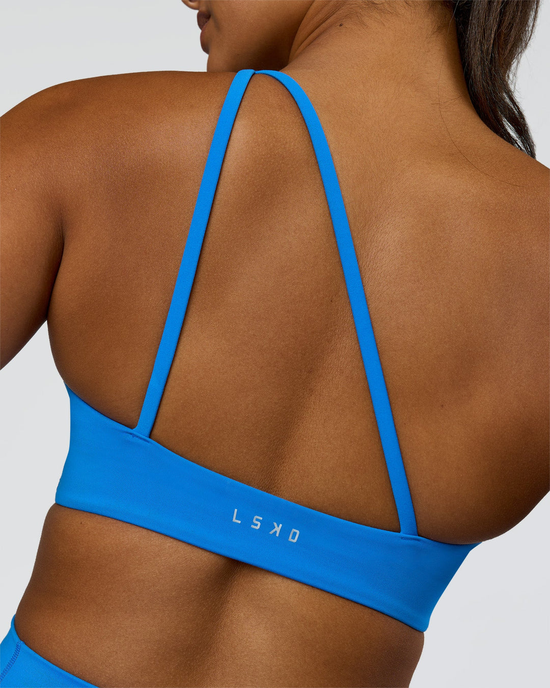 Woman wearing Muse Asymmetric Sports bra - Palace Blue | Model:Rosie | Size:S