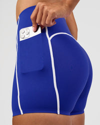 Woman wearing Power Ultra High-Rise 4" Short Pockets - Electric Indigo | Model:Rhiley | Size:S