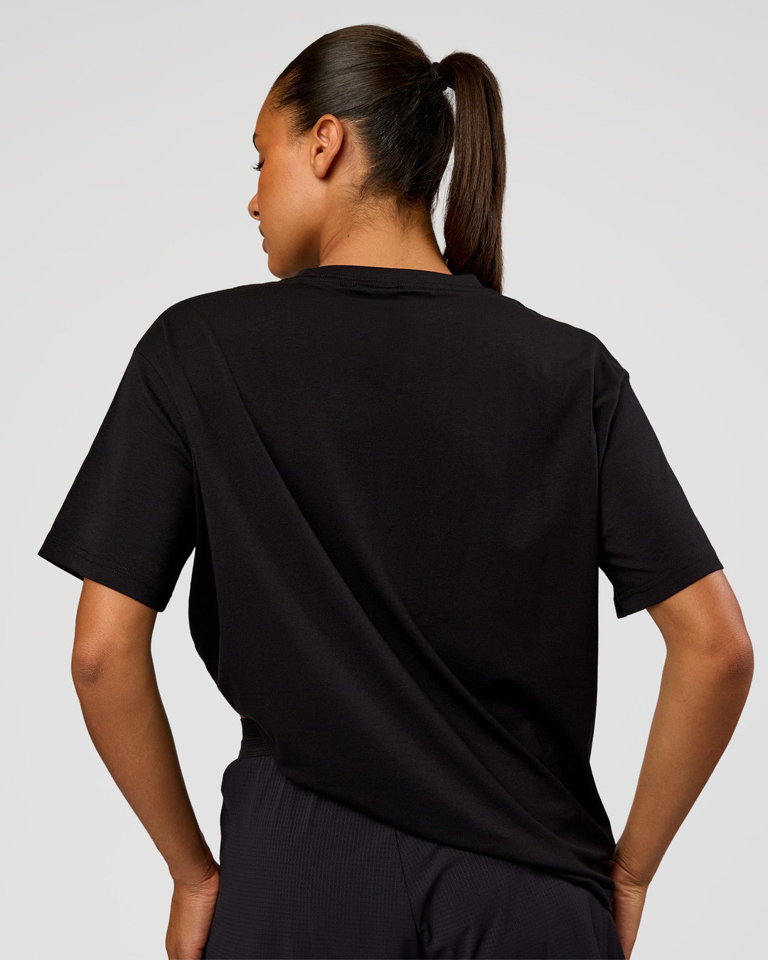 Woman wearing Pride Go-To FLXCotton Oversized Tee - Black | Model:Rosie | Size:S