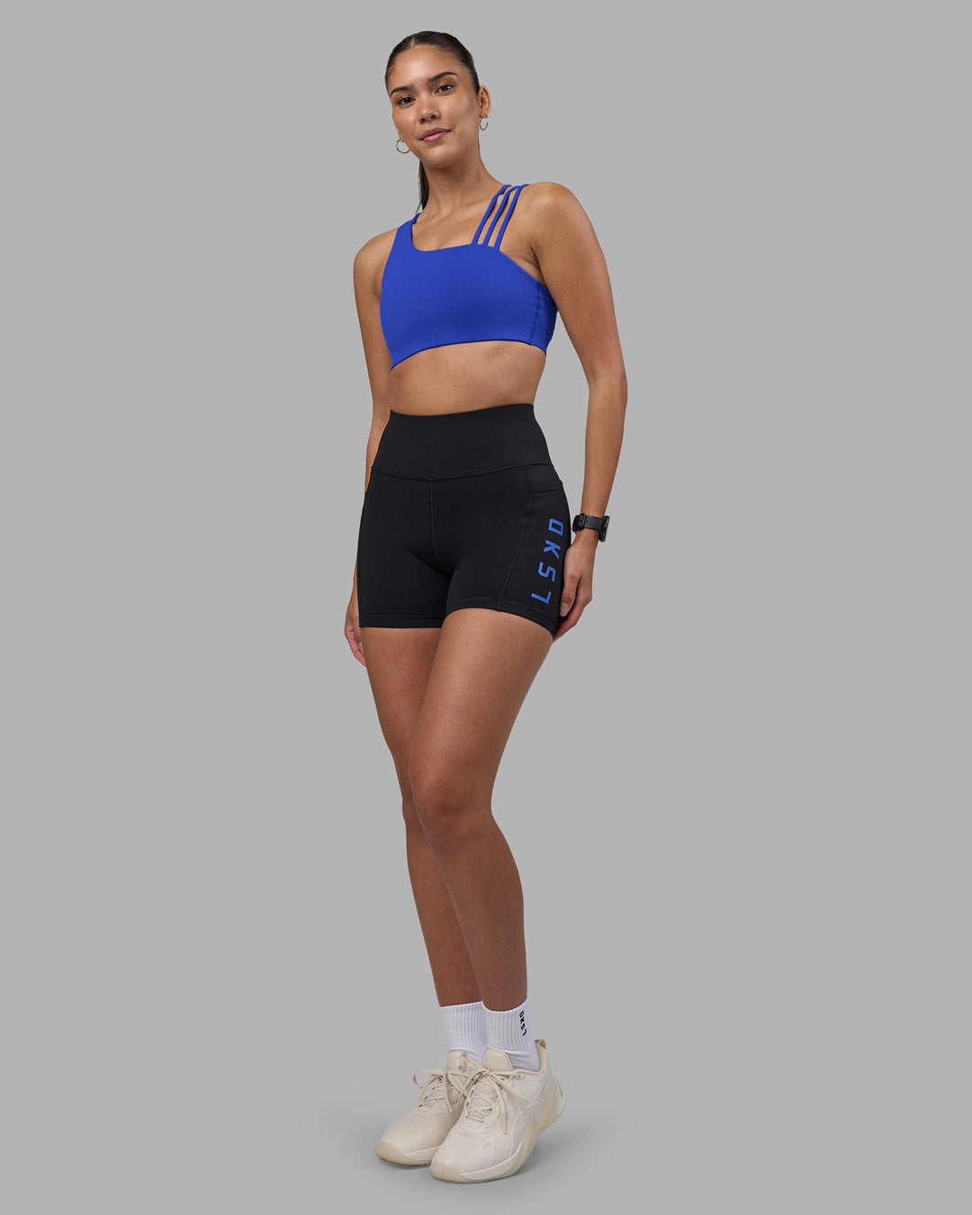 Woman wearing Rep Ultra High-Rise 4&quot; Short Pockets - Black-Power Cobalt | Model:Rhiley | Size:S