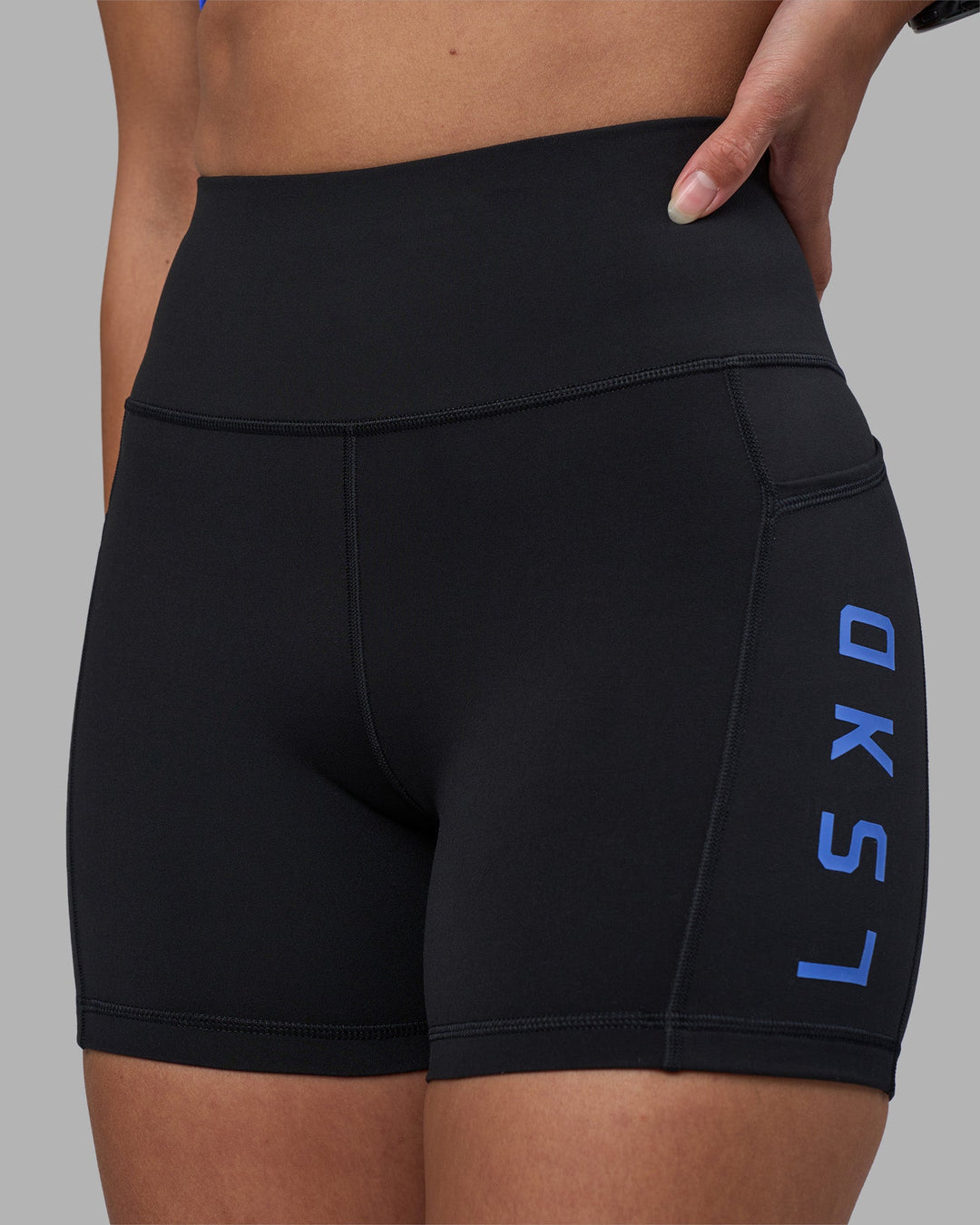 Woman wearing Rep Ultra High-Rise 4&quot; Short Pockets - Black-Power Cobalt | Model:Rhiley | Size:S