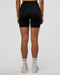 Woman wearing Rep Ultra High-Rise 6" Short Pockets - Black-Electric Indigo | Model:Evie | Size:S