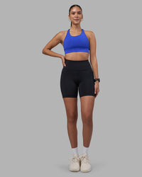 Woman wearing Rep Ultra High-Rise 6" Short Pockets - Black-Power Cobalt | Model:Rhiley | Size:S