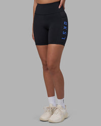 Woman wearing Rep Ultra High-Rise 6" Short Pockets - Black-Power Cobalt | Model:Rhiley | Size:S