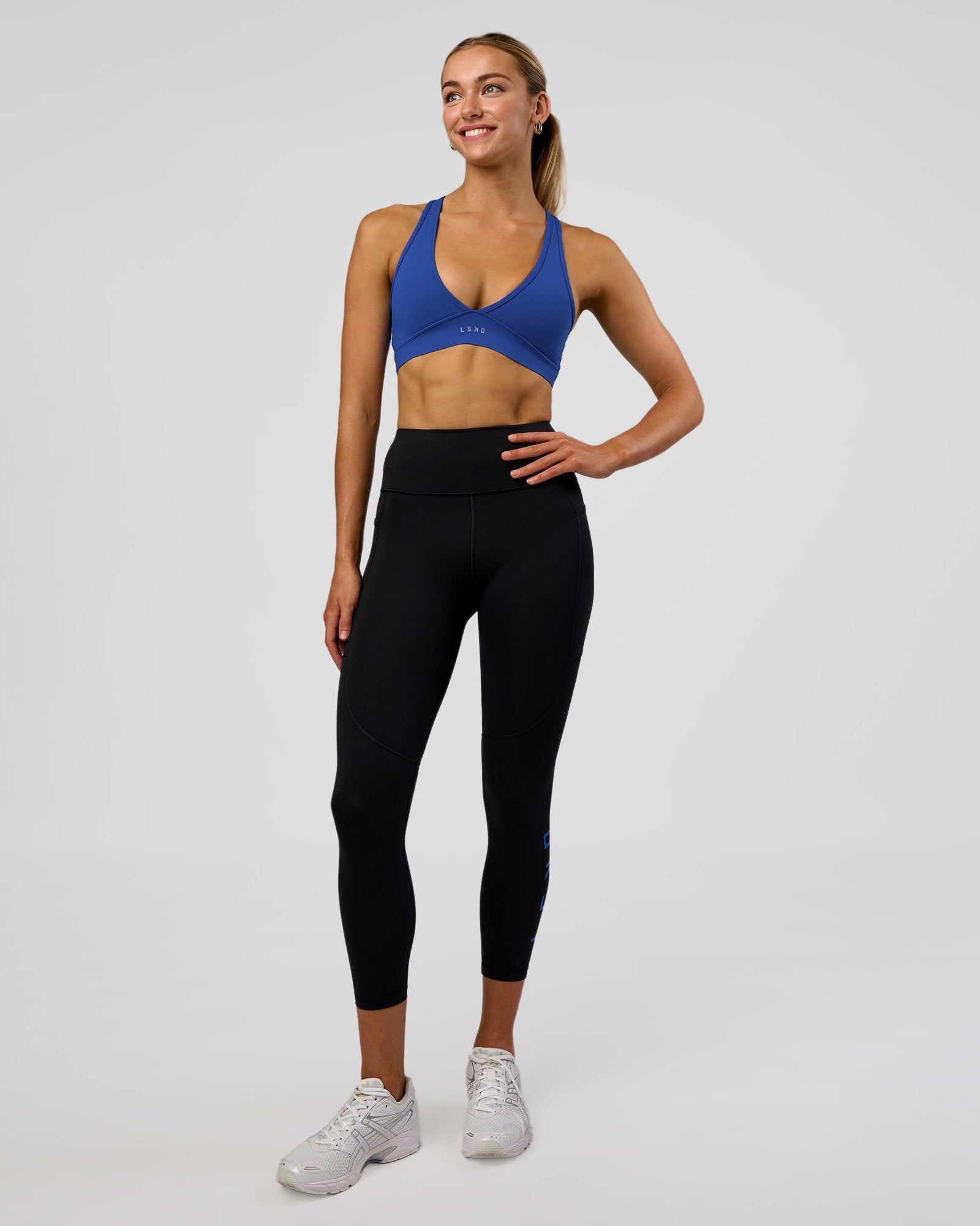 Woman wearing Rep Ultra High-Rise 7/8 Legging Pockets - Black-Electric Indigo | Model:Evie | Size:S