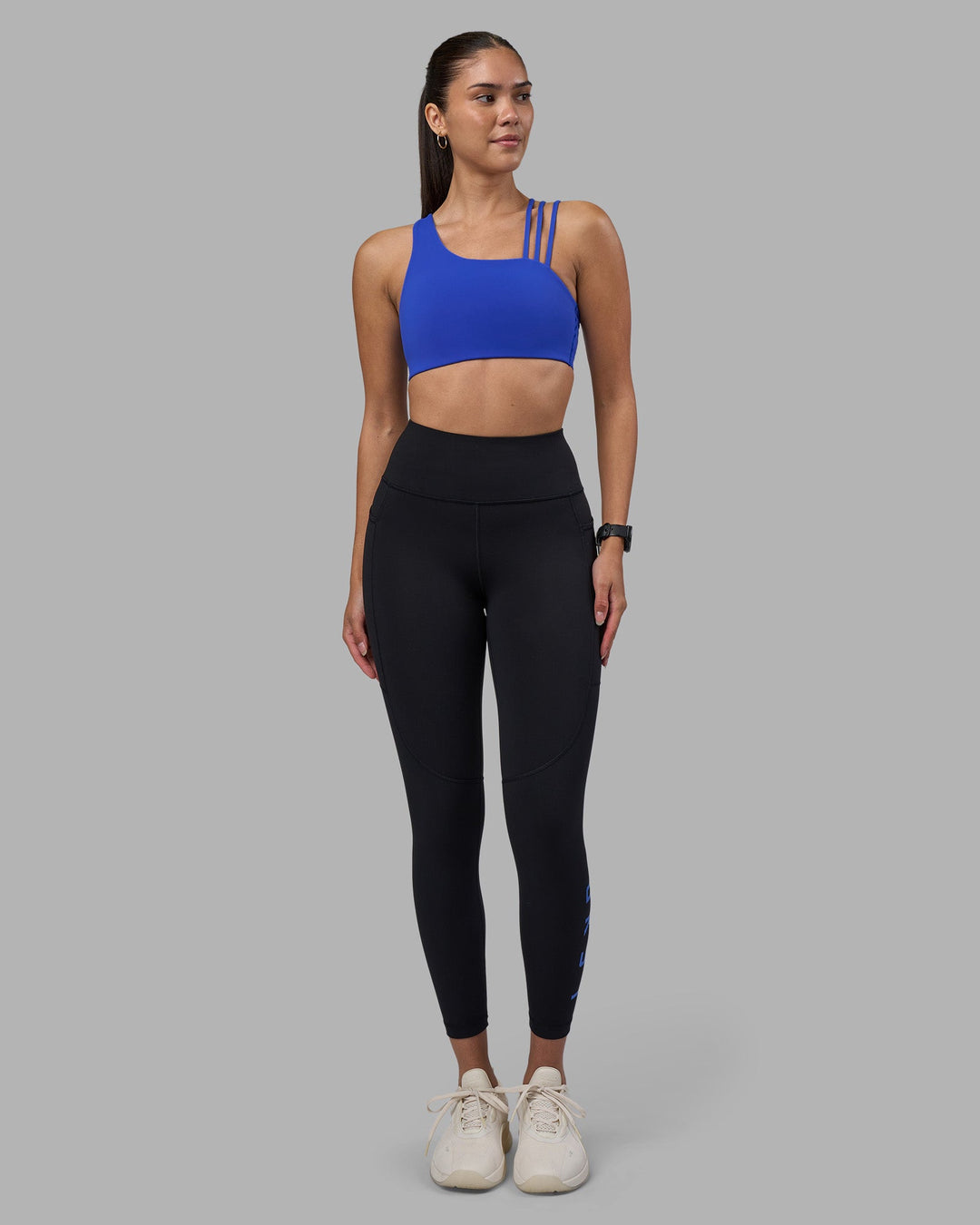 Woman wearing Rep Ultra High-Rise 7/8 Legging Pockets - Black-Power Cobalt | Model:Rhiley | Size:S