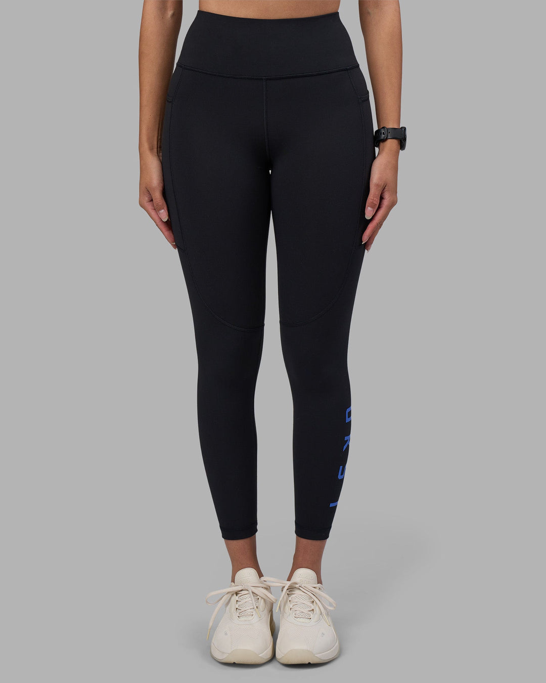 Woman wearing Rep Ultra High-Rise 7/8 Legging Pockets - Black-Power Cobalt | Model:Rhiley | Size:S