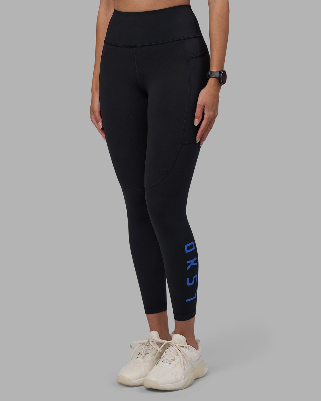 Woman wearing Rep Ultra High-Rise 7/8 Legging Pockets - Black-Power Cobalt | Model:Rhiley | Size:S