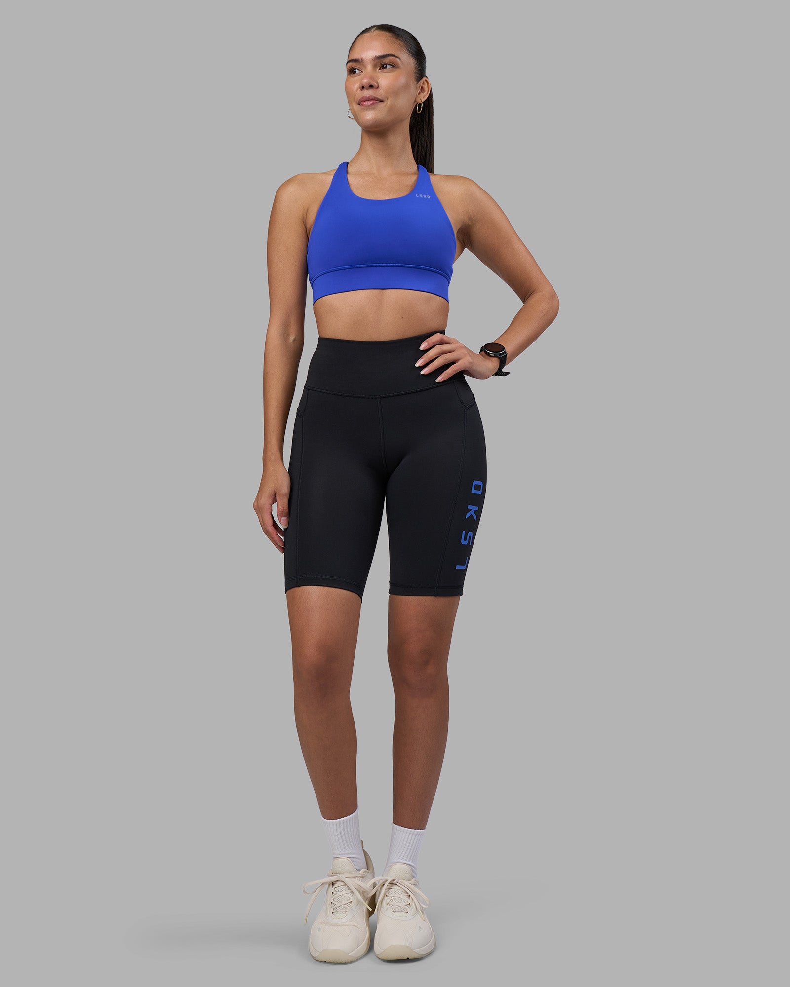 Woman wearing Rep Ultra High-Rise 9" Short Pockets - Black-Power Cobalt | Model:Rhiley | Size:S