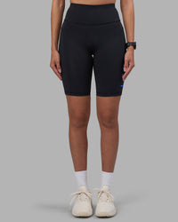 Woman wearing Rep Ultra High-Rise 9" Short Pockets - Black-Power Cobalt | Model:Rhiley | Size:S