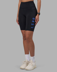 Woman wearing Rep Ultra High-Rise 9" Short Pockets - Black-Power Cobalt | Model:Rhiley | Size:S
