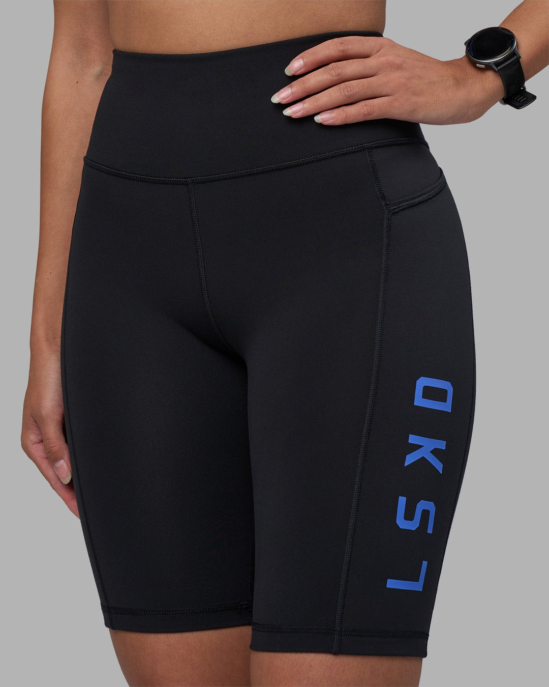 Woman wearing Rep Ultra High-Rise 9" Short Pockets - Black-Power Cobalt | Model:Rhiley | Size:S