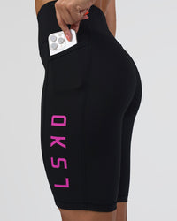 Woman wearing Rep Ultra High-Rise 9" Short Pockets - Black-Ultra Fuchsia | Model:Abbey | Size:S