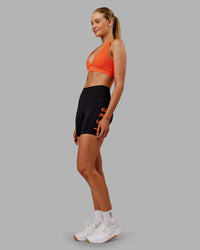 Woman wearing Rep Ultra High-Rise 6" Short Pockets - Black-Ultra Orange | Model:Ella | Size:S
