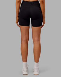 Woman wearing Rep Ultra High-Rise 6" Short Pockets - Black-Ultra Orange | Model:Ella | Size:S
