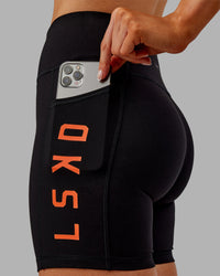 Woman wearing Rep Ultra High-Rise 6" Short Pockets - Black-Ultra Orange | Model:Ella | Size:S