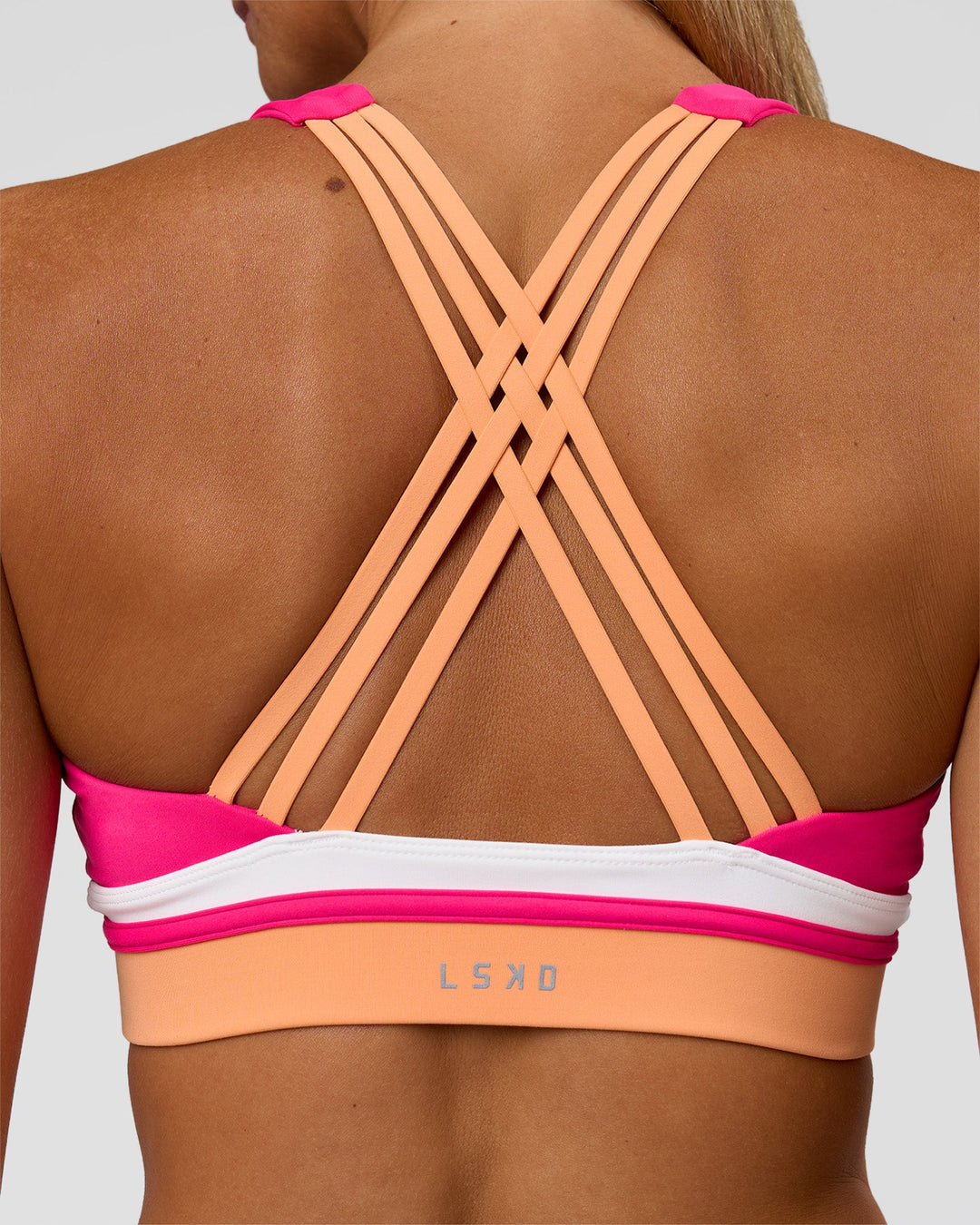 Woman wearing Revitalise Flash Sports Bra - Ultra Pink-Cantaloupe-White | Model:Amity | Size:S