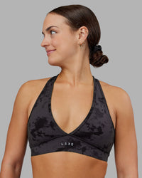 Woman wearing Stamina Sports Bra - Black Tie Dye | Set:true | Angle:front | Model:Keisha | Size:S