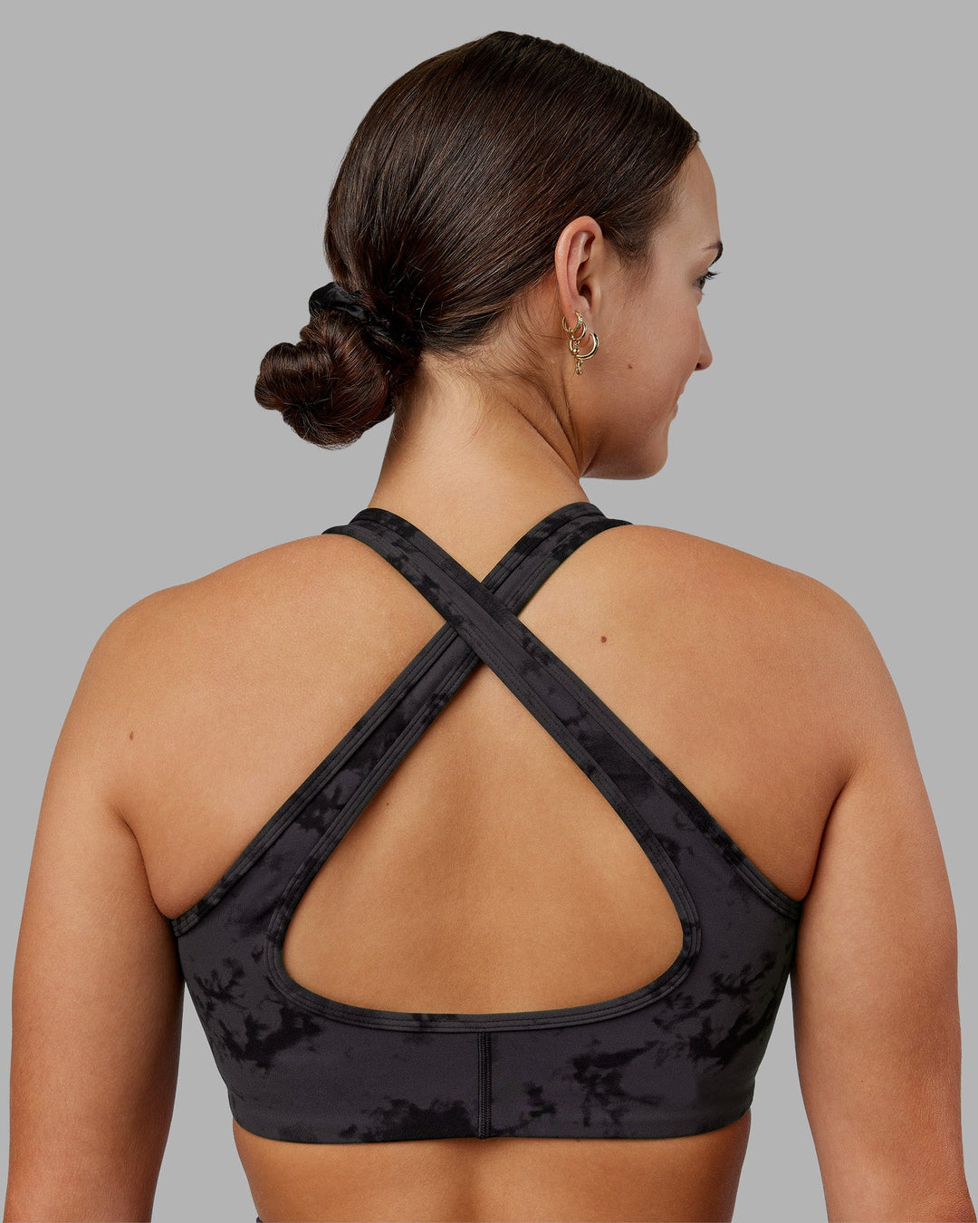 Woman wearing Stamina Sports Bra - Black Tie Dye | Set:true | Angle:back | Model:Keisha | Size:S