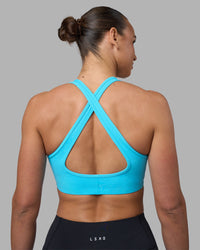 Woman wearing Stamina Sports Bra - Blue Atoll | Set:true | Angle:back | Model:Sophie | Size:S