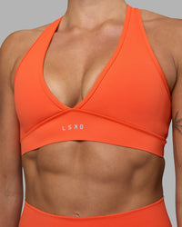 Woman wearing Stamina Sports Bra - Ultra Orange | Set:true | Angle:closeup | Model:Katie | Size:S