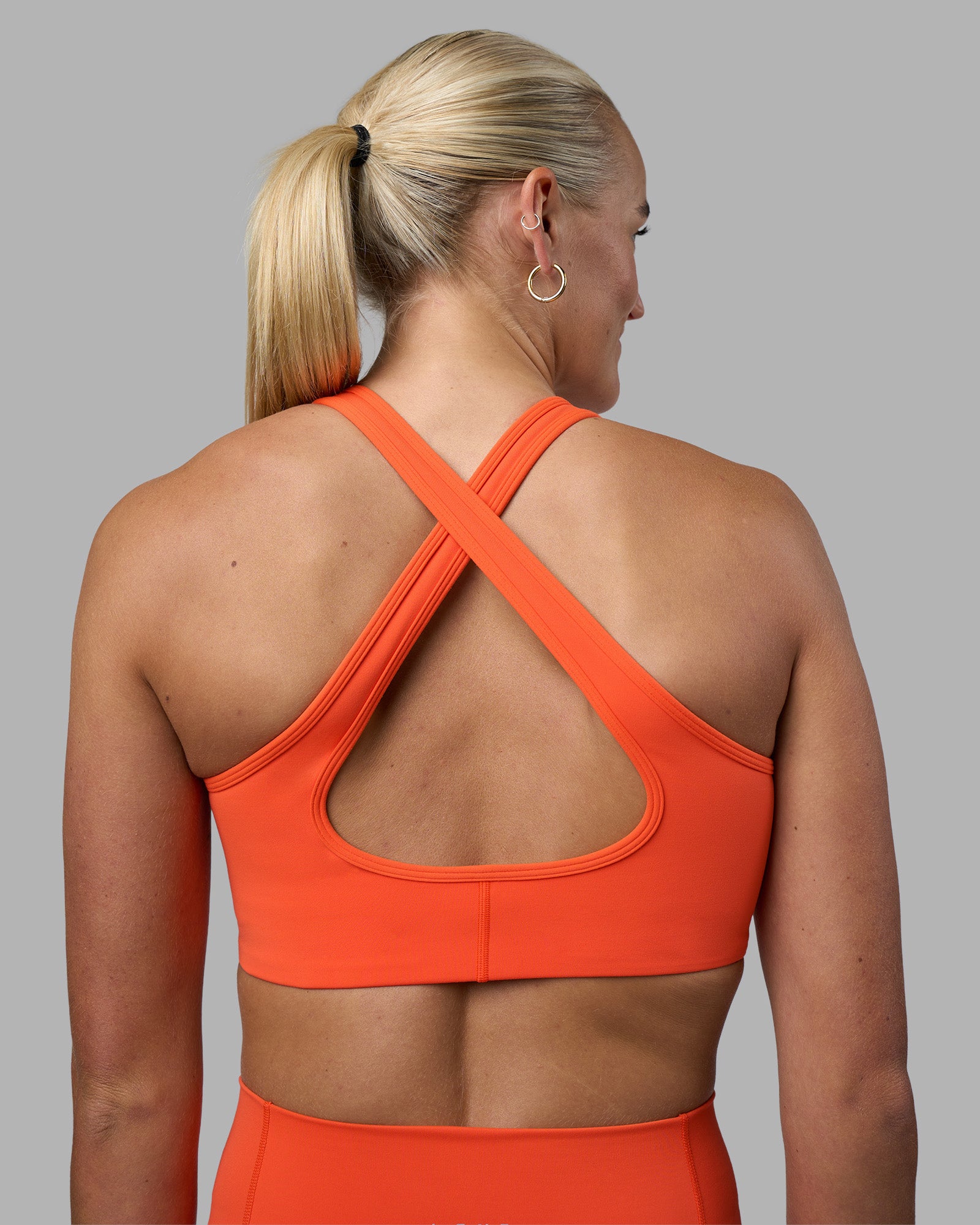 Woman wearing Stamina Sports Bra - Ultra Orange | Model:Katie | Size:S